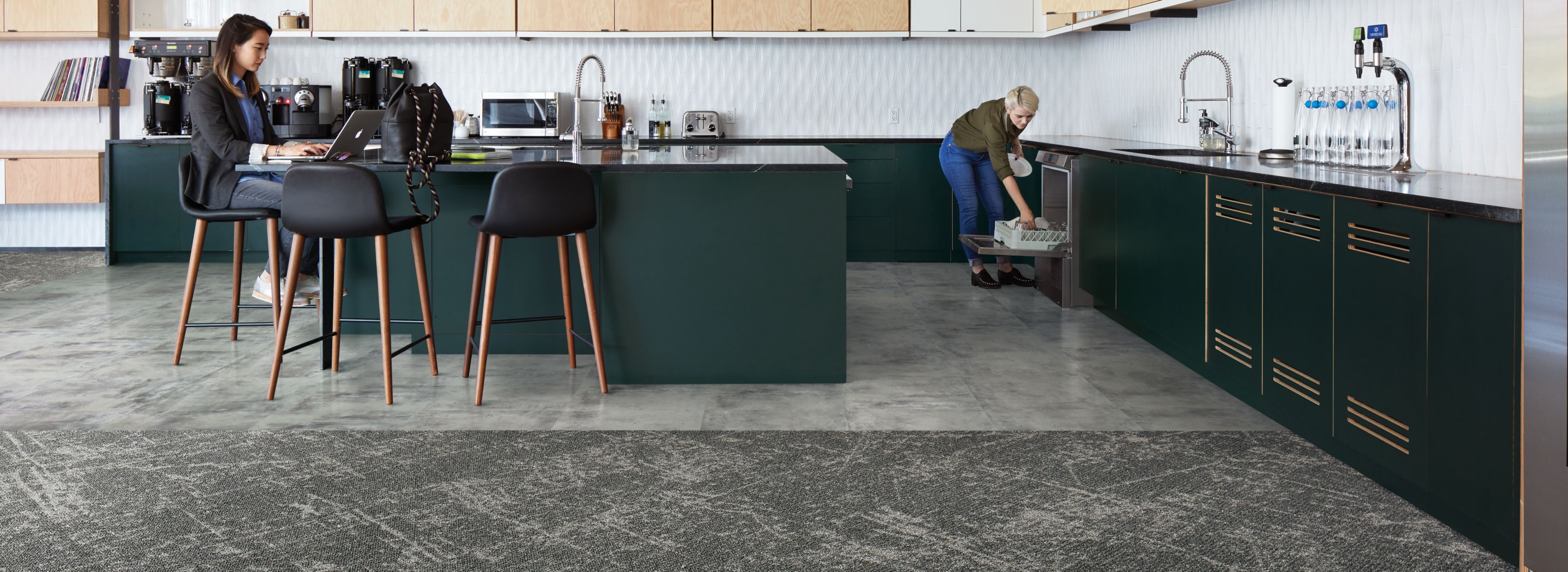 Interface Ice Breaker carpet tile and Textured Stones LVT in kitchen area with women lodaing dish washer and women working on computer image number 1